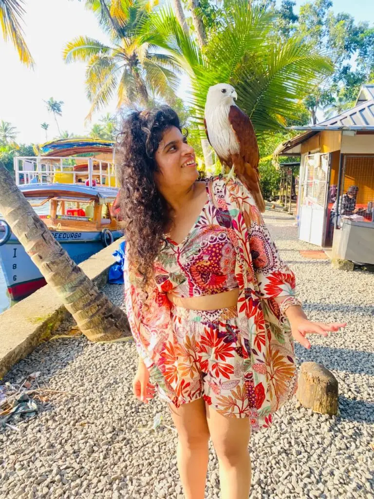 Tourist enjoying the backwaters with an eagle, which is one of the top 5 things to do in Alleppey.