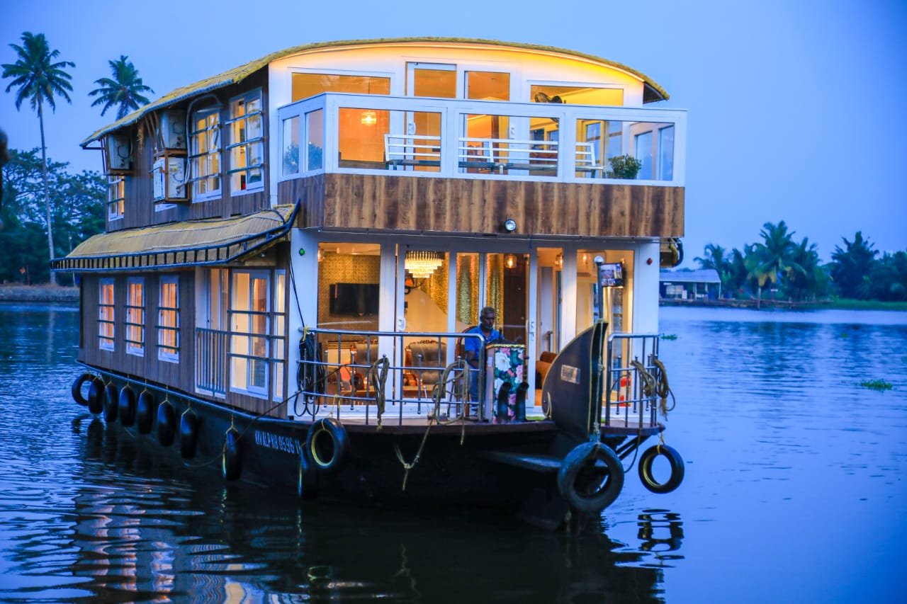 Evening view of an illuminated 5 bedroom houseboat Alleppey on the calm backwaters.