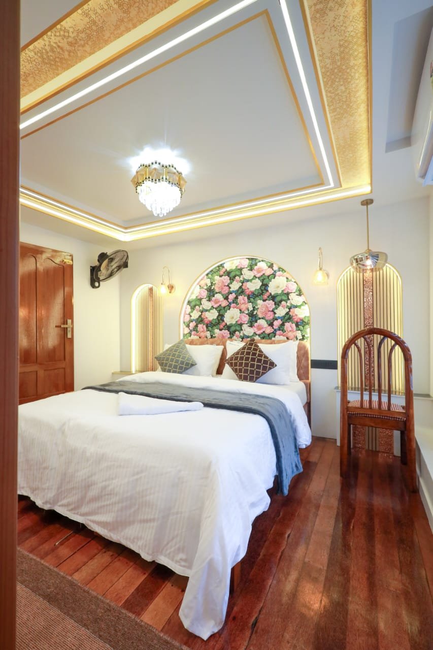 Private AC bedroom with floral decor inside a luxury Alleppey boat.