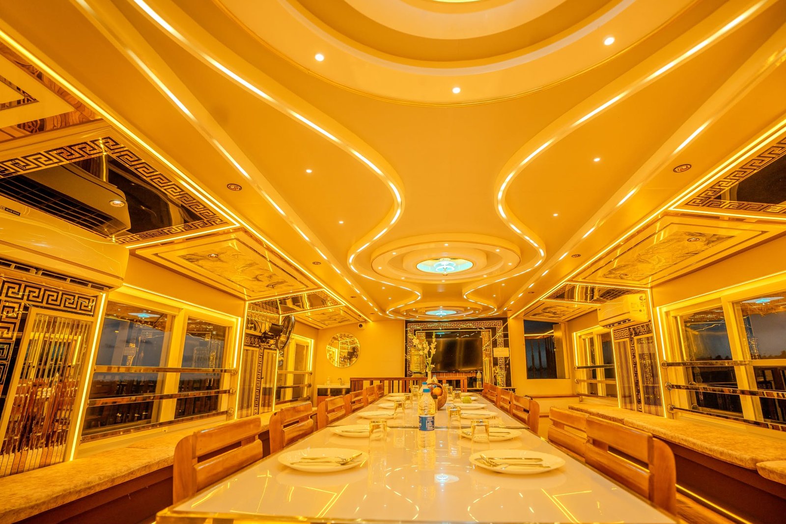 Elegant dining setup under custom LED lighting perfect for large groups in a premium Kerala houseboat.