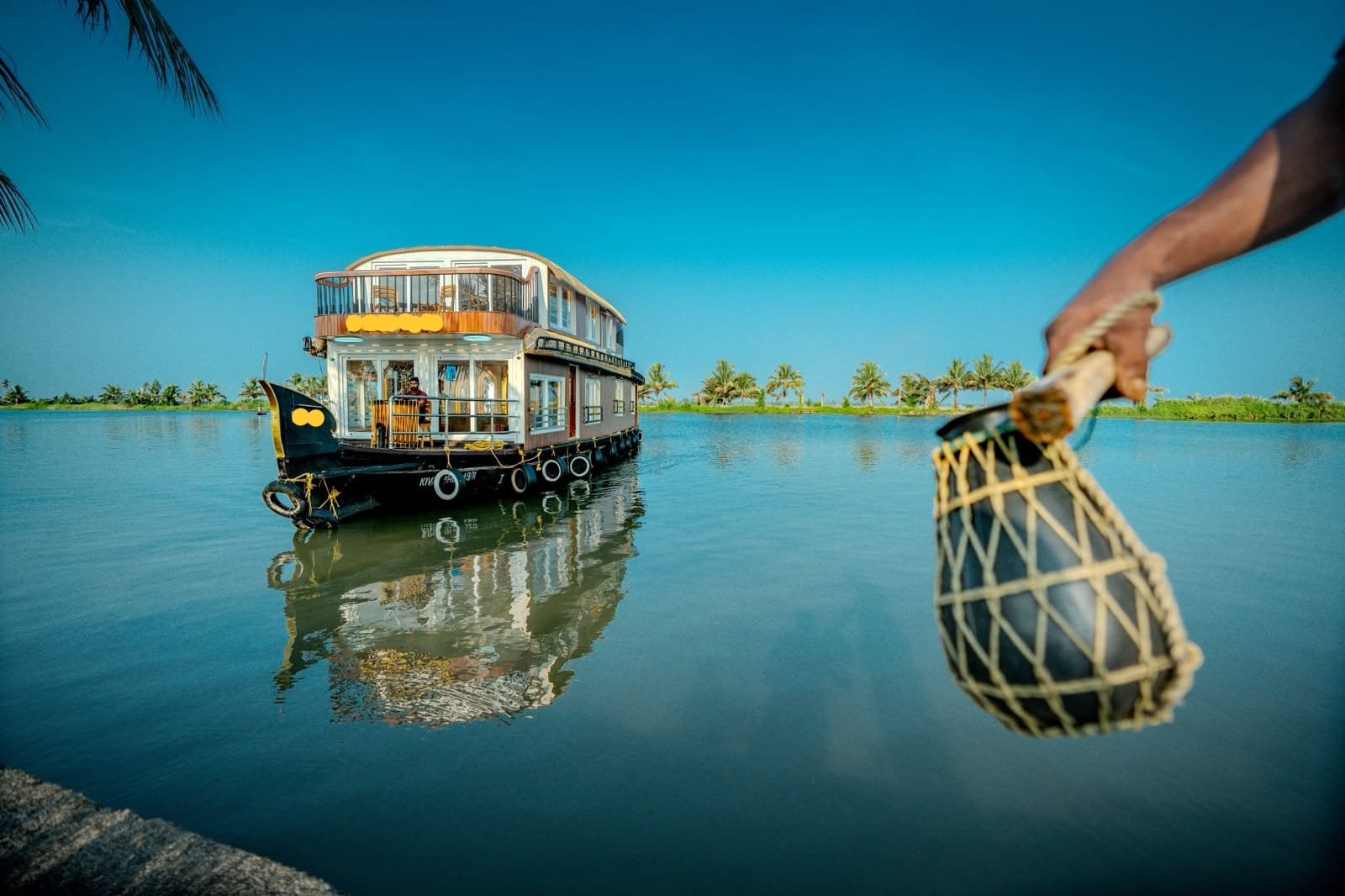 Scenic view of a 3 bedroom houseboat Alleppey docked on Vembanad Lake showcasing Kerala culture.