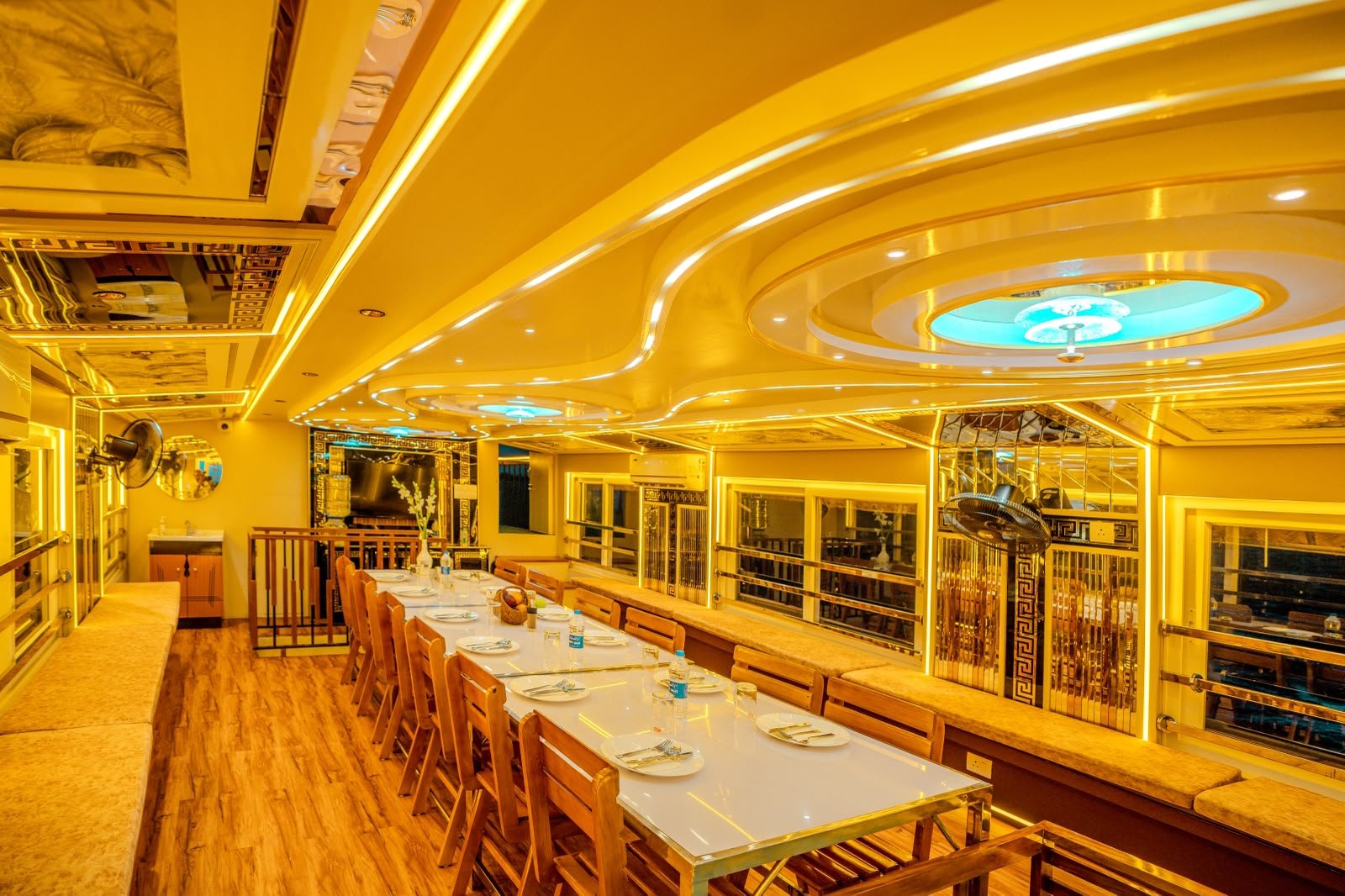Premium dining area with a long table and beautiful ambient lighting on a family-friendly houseboat stay.