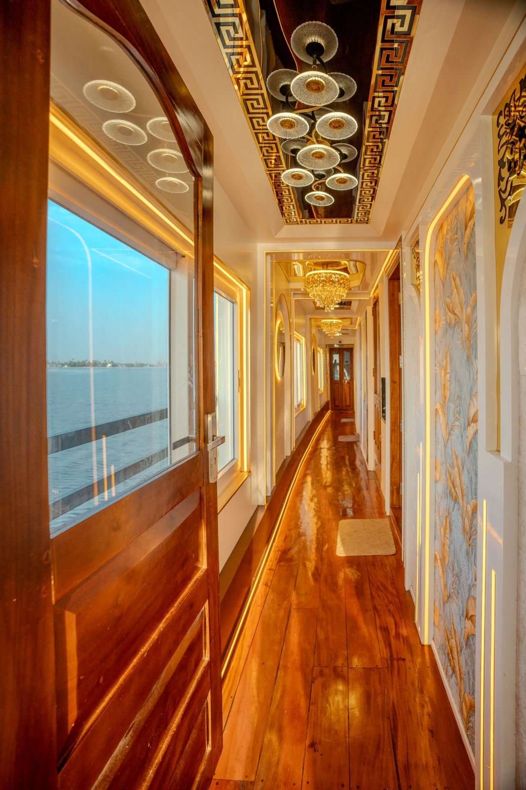 Elegant illuminated hallway with wooden flooring inside a private Kerala backwater houseboat.