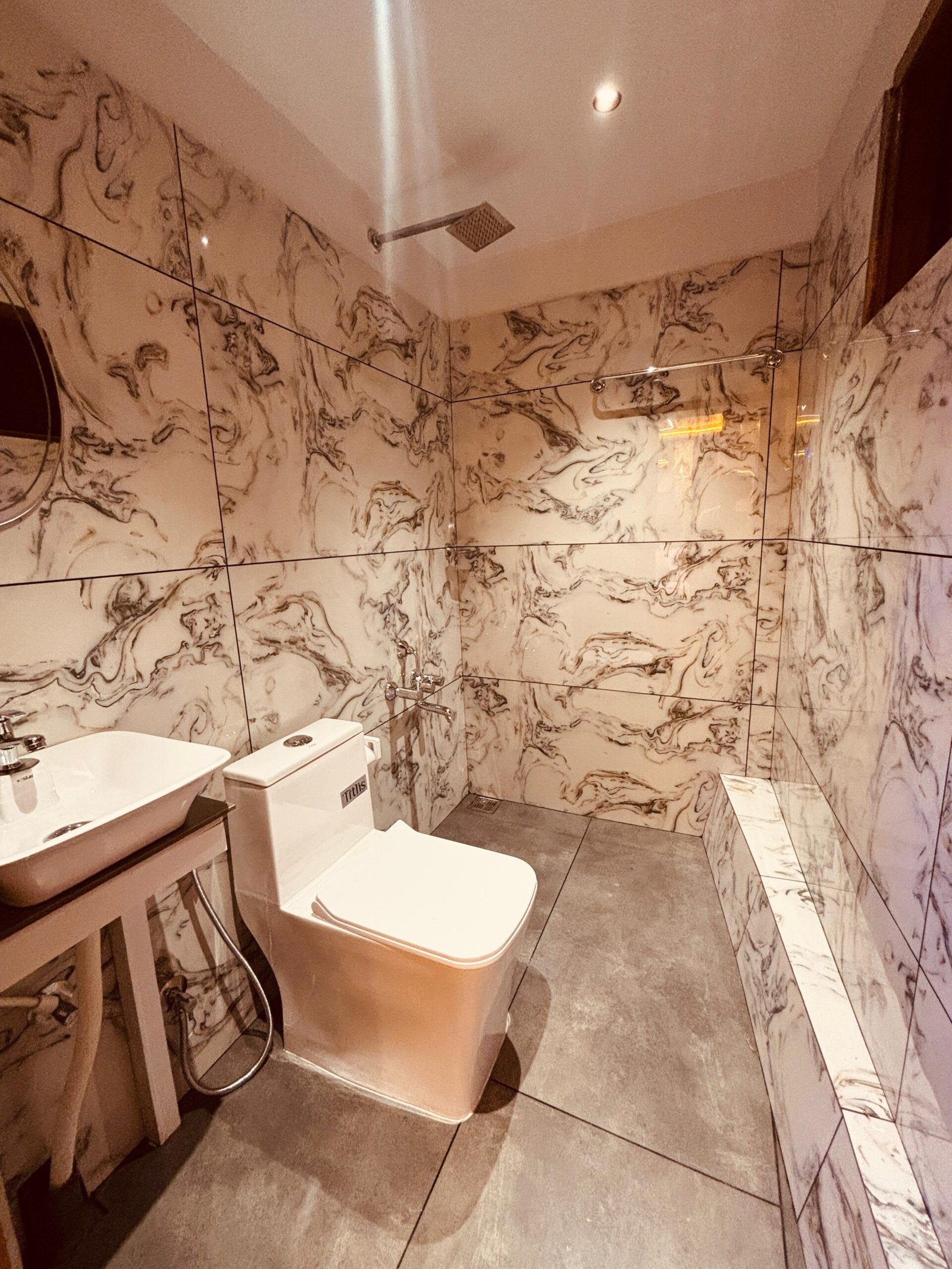 Attached Bathroom with Shower Fully equipped attached bathroom with a shower, western toilet, and marble-style tiles docked on Vembanad Lake.