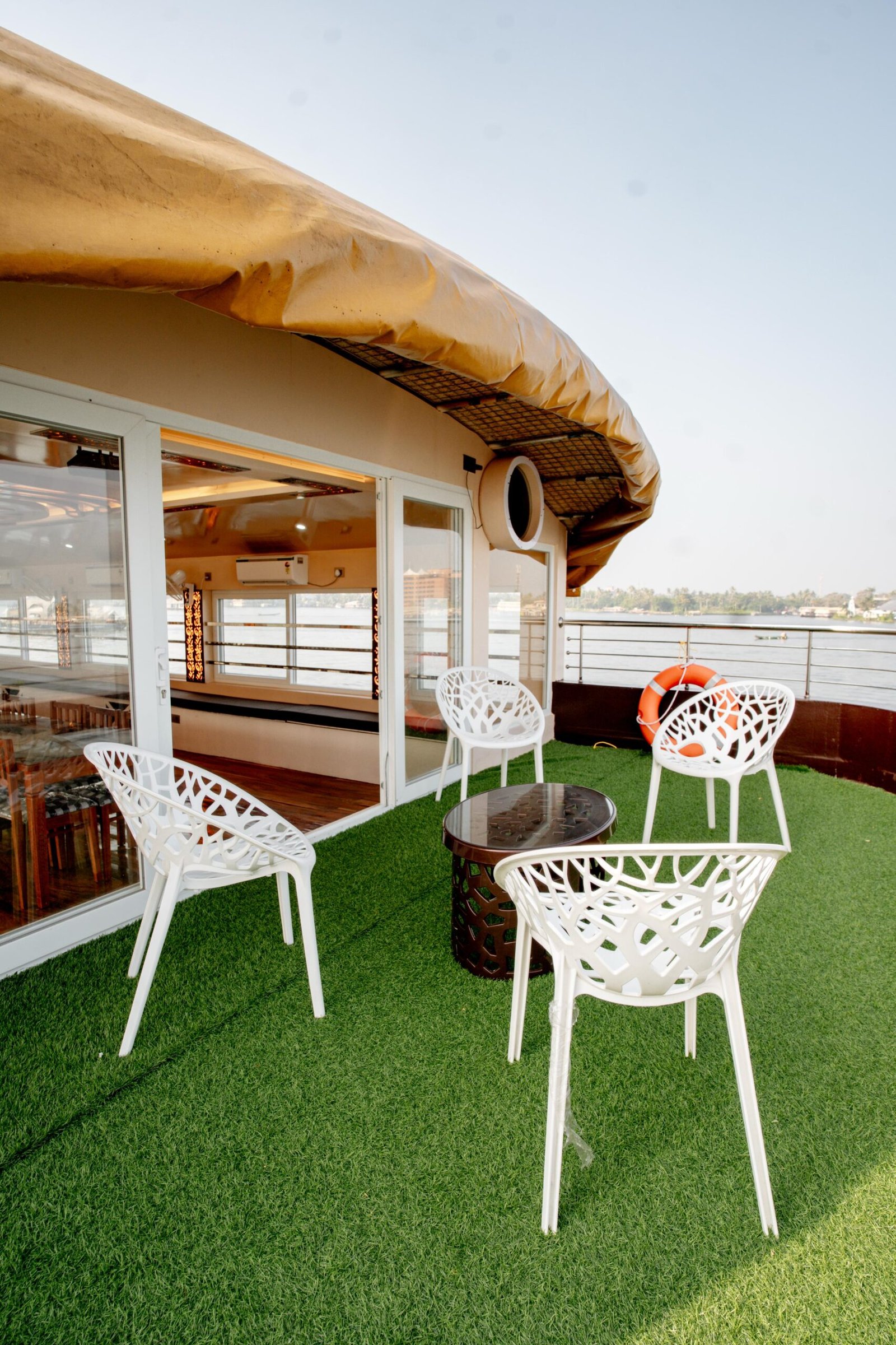 Relaxing outdoor balcony deck with artificial grass and seating on our private 7 bedroom houseboat Alleppey