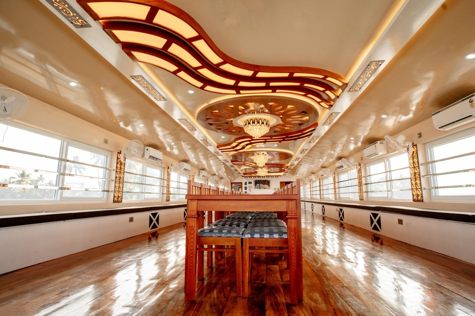 Expansive dining hall with elegant ceiling lights ready for large groups on a 7 bedroom houseboat Alleppey