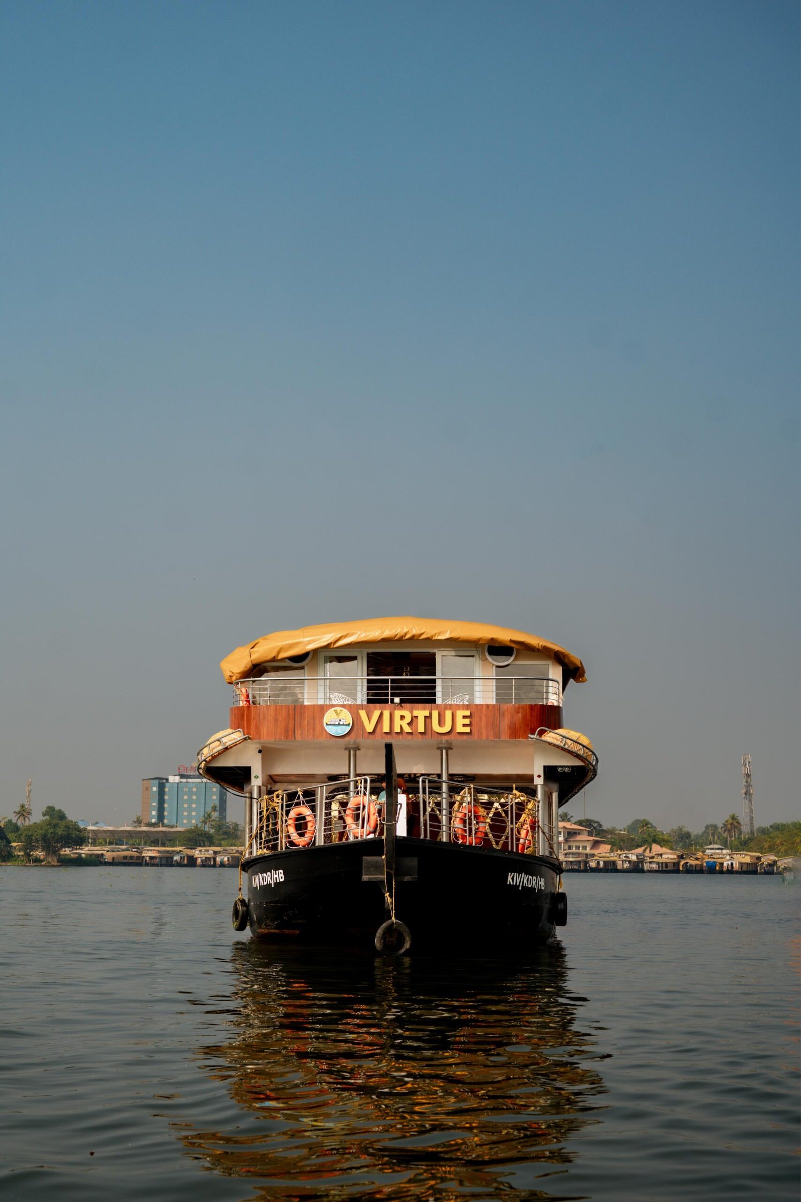 Front exterior view of the premium Virtue 7 bedroom houseboat cruising through Alleppey backwaters
