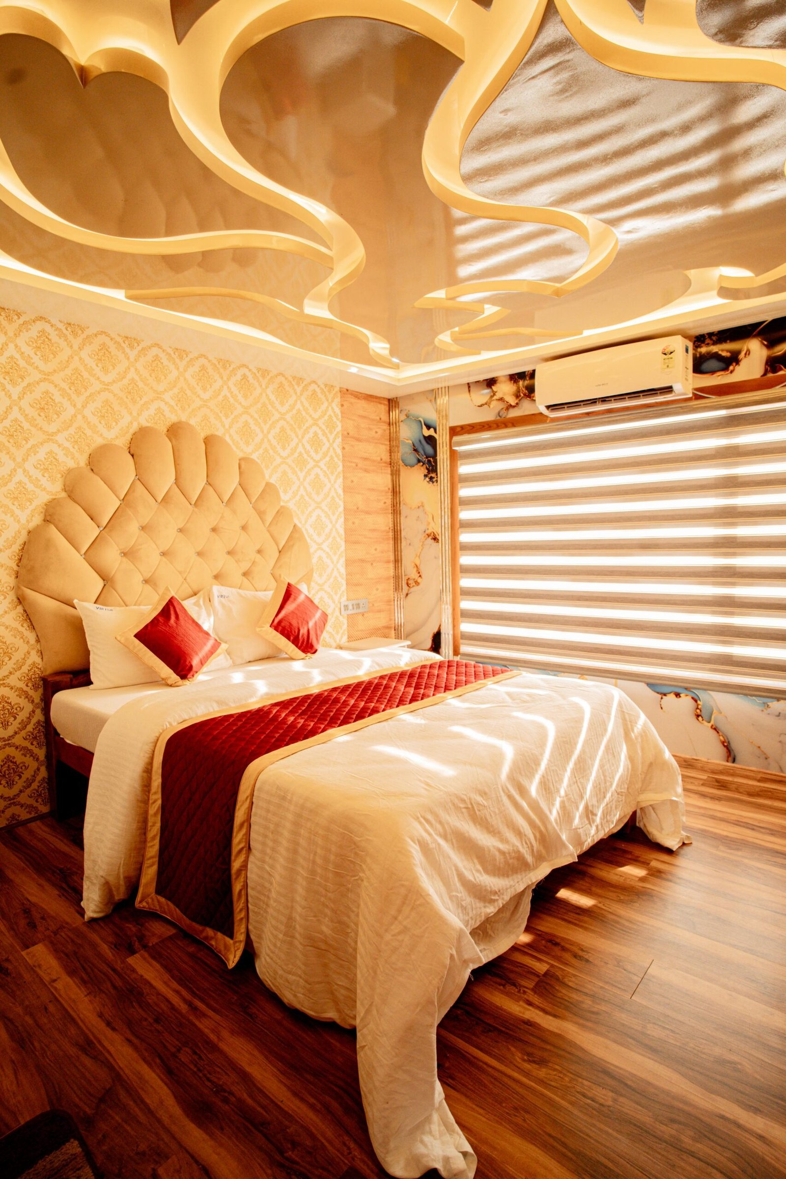 Air-conditioned guest bedroom with a beige scalloped headboard on an Alleppey 7 bedroom houseboat