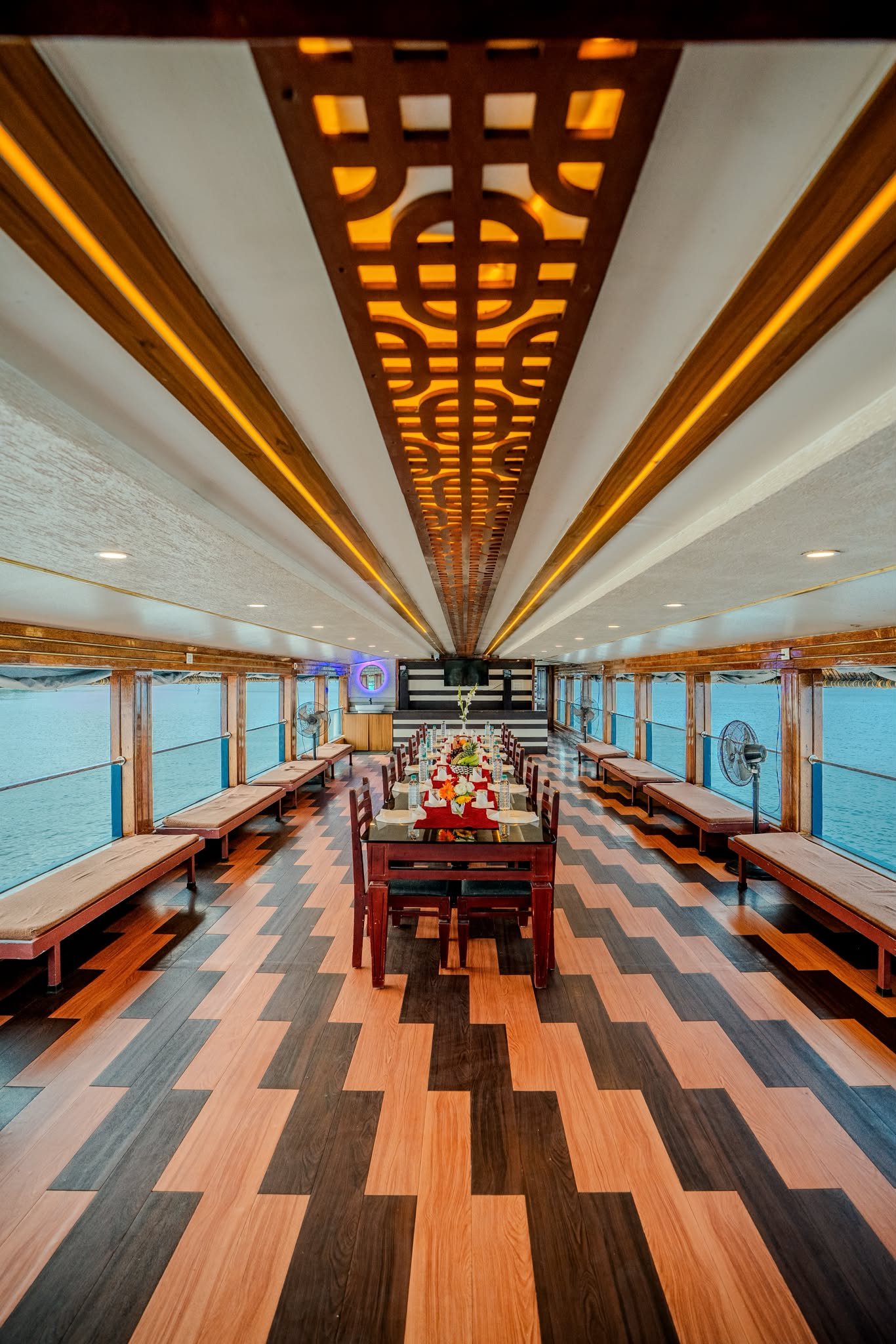 Long Wooden Corridor - 6 Bedroom Houseboat Alleppey A stunning view of the long wooden corridor and dining area typical of a luxury 6 bedroom houseboat Alleppey.