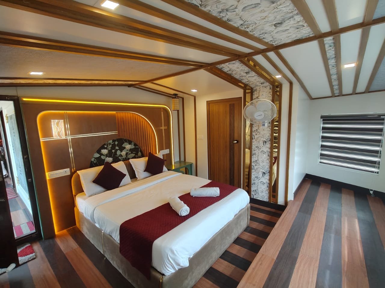 Luxury Living Area - 6 Bedroom Houseboat Alleppey Expansive air-conditioned living room with comfortable brown sofas and a flat screen TV in the 6 bedroom houseboat Alleppey.