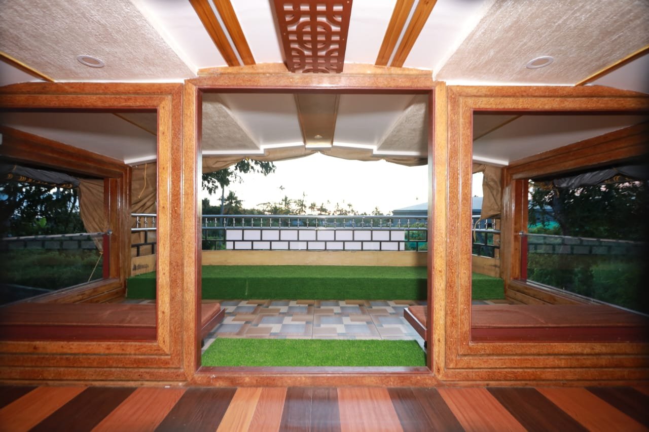 Premium Yellow Bedroom - 6 Bedroom Houseboat Alleppey Beautifully designed bedroom with warm yellow accents, round mirrors, and plush bedding on a private 6 bedroom houseboat Alleppey.