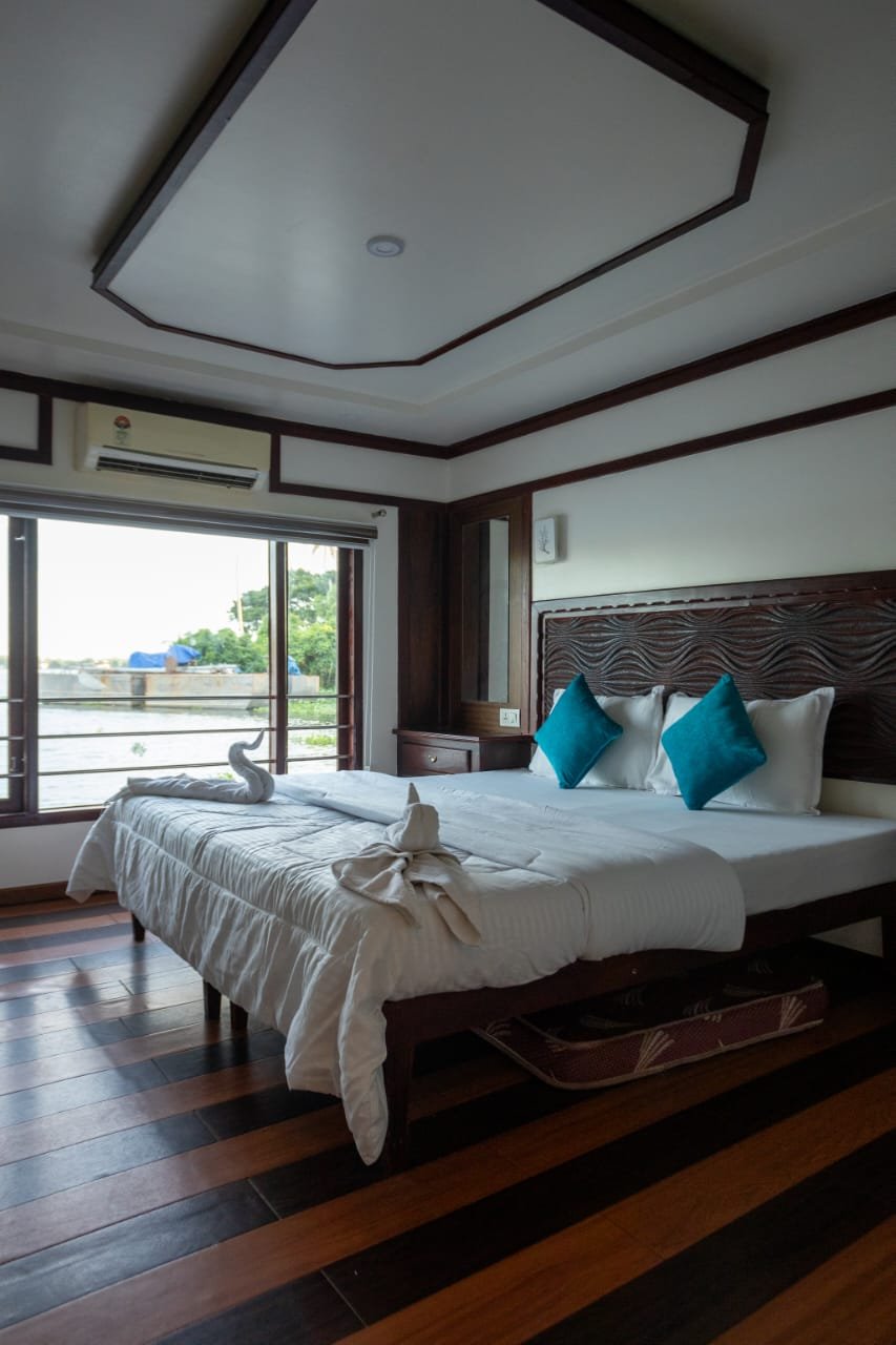 Lake View AC Bedroom - 6 Bedroom Houseboat Alleppey Spacious air-conditioned guest room with lake views inside a 6 bedroom houseboat Alleppey