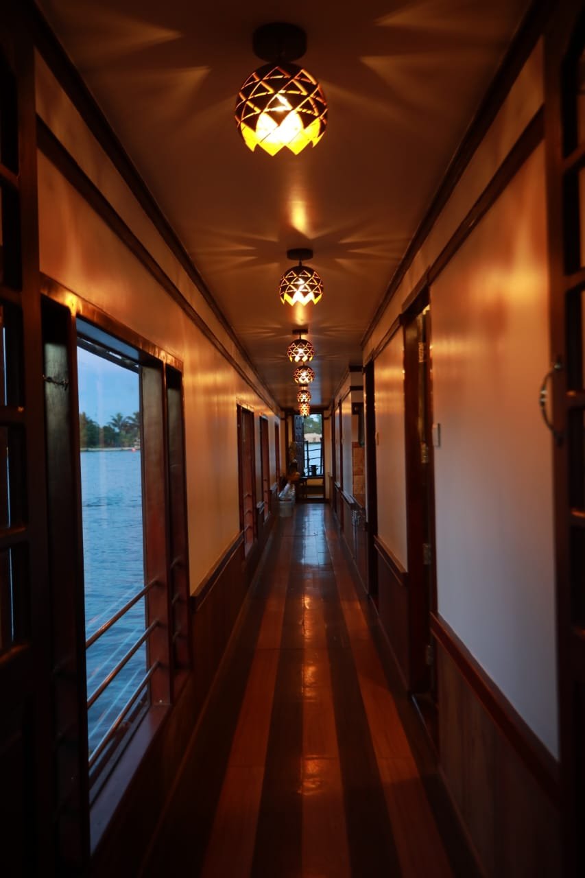 Traditional Wooden Corridor Interior Elegant wooden hallway illuminated with warm hanging lights on our Alleppey backwater cruise