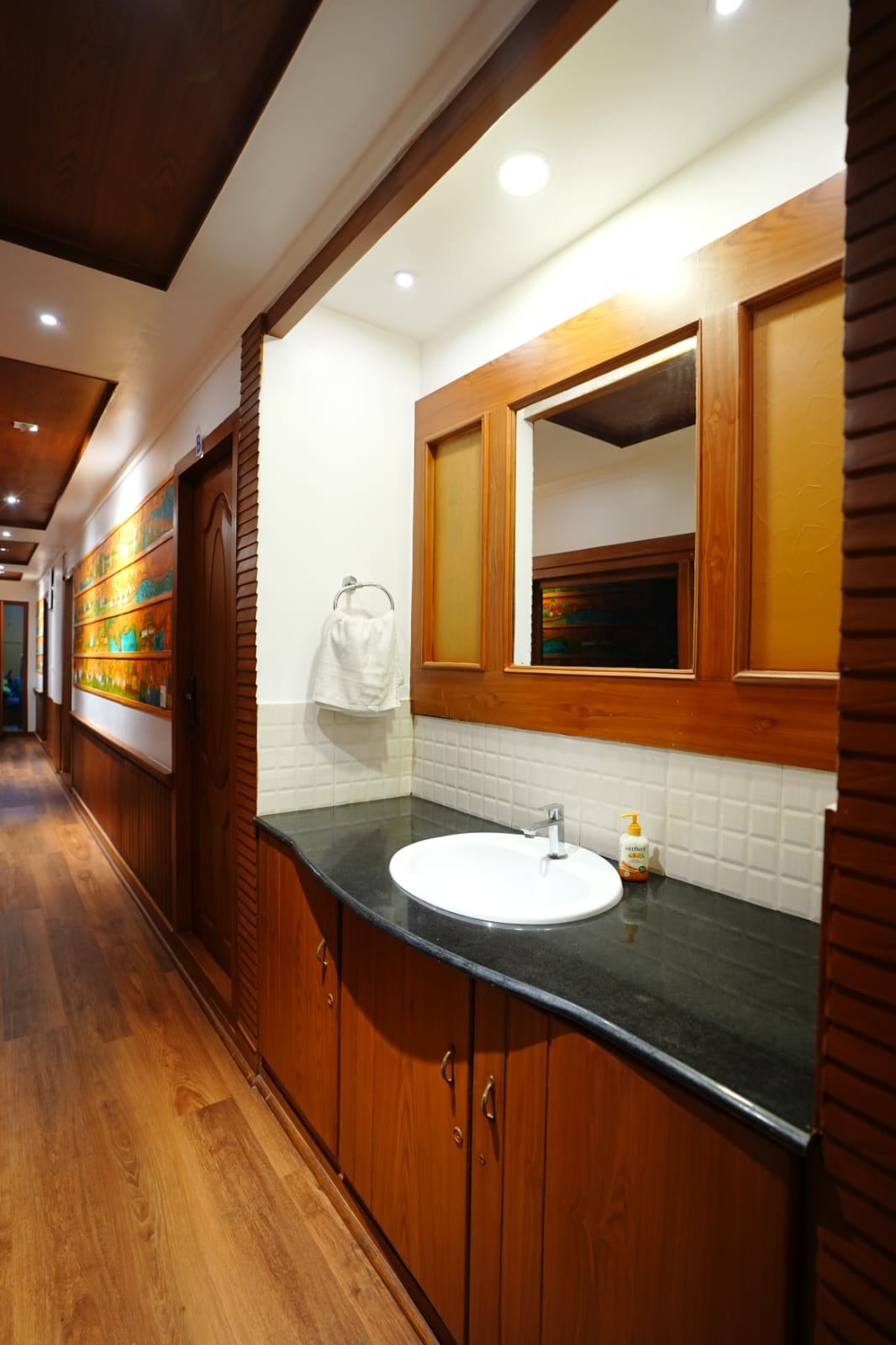 Convenient corridor washbasin and mirror setup on our family-friendly Kerala backwater boat.
