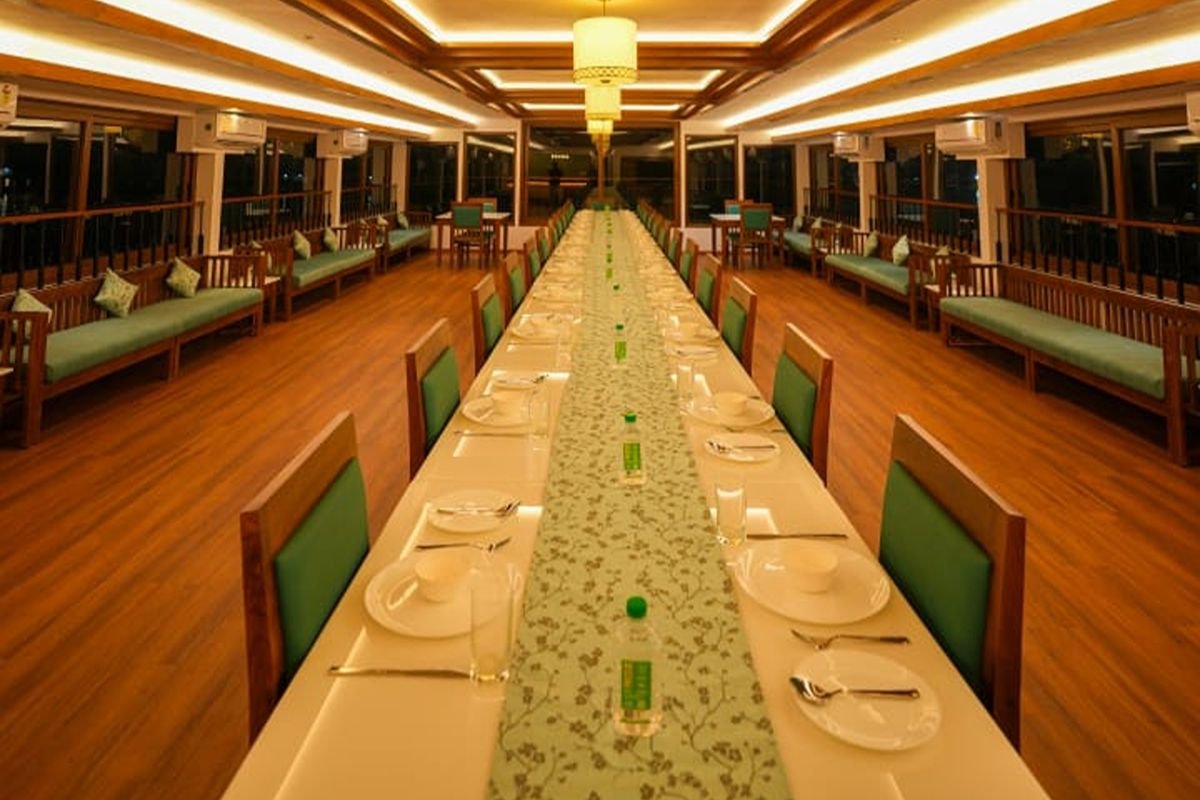 Group Dining Setup in 12 Bedroom Houseboat Alleppey Long table setup for group dining on the 12 bedroom houseboat Alleppey