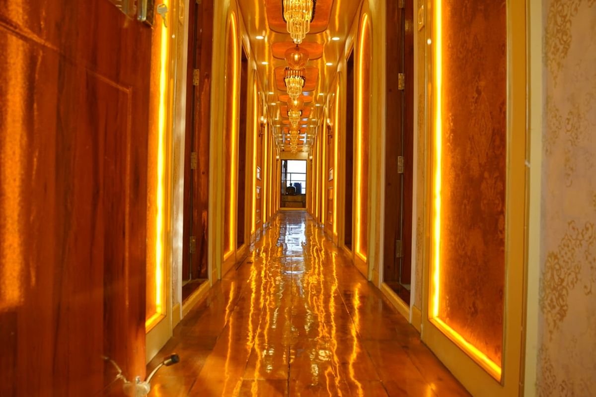Corridor in 14 Bedroom Houseboat Alleppey Illuminated wooden hallway inside a luxury 14 bedroom houseboat Alleppey