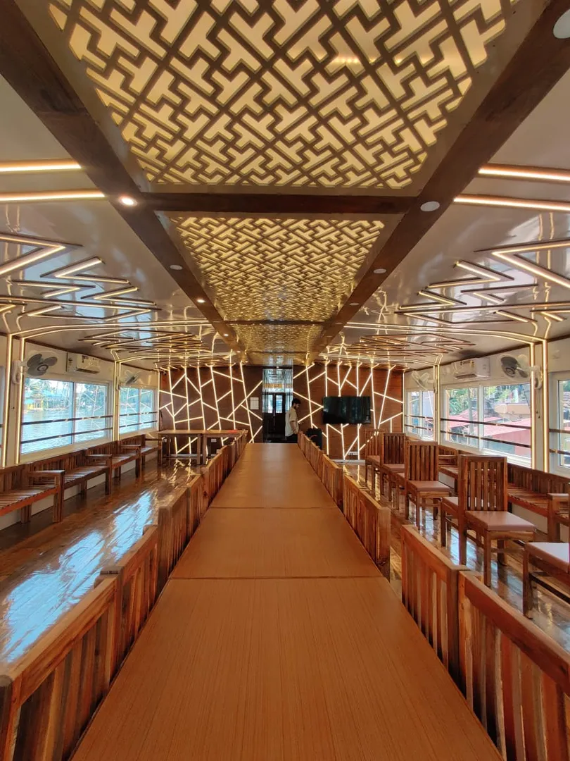 Expansive wooden lounge and dining deck with decorative lighting on the 10 bedroom houseboat alleppey